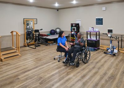 a rehab therapist and a resident in the rehab gym at Huntington Park Nursing Center