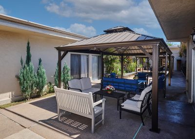 A shaded seating area outside in the back patio area at Huntington Park Nursing Center